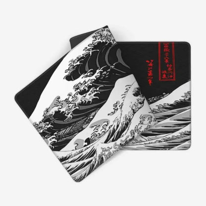 Black, white, and red desk mat featuring a stylized wave design, with a second matching mat partially underneath.