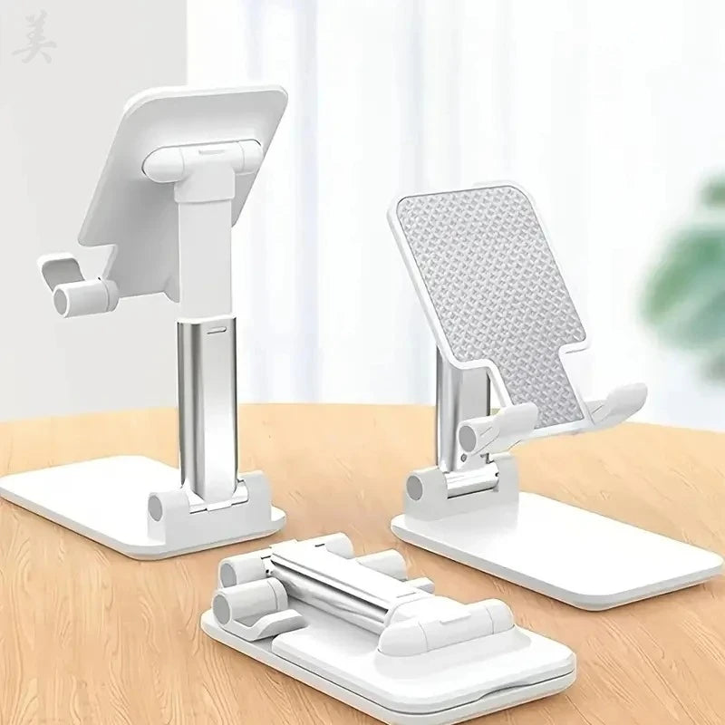 Two white and silver adjustable phone stands, one extended and one folded flat on a wooden surface.