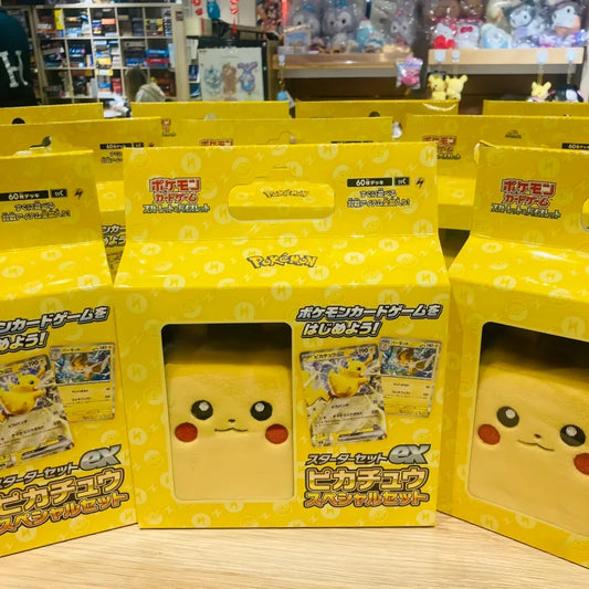 Yellow Pikachu Pokémon card gift box with a plush Pikachu face visible through a front window.
