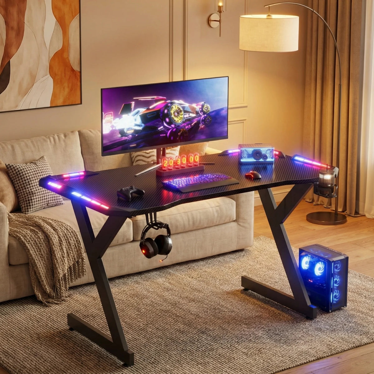 Black Y-shaped gaming desk with RGB LED lights on the corners, a monitor, keyboard, mouse, and headphones.