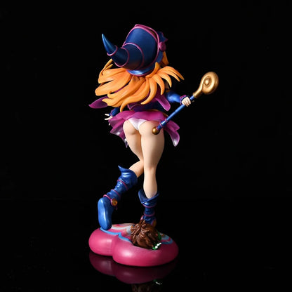 Dark Magician Girl anime figure from behind, in a blue and pink outfit, holding a staff, standing on a heart base.