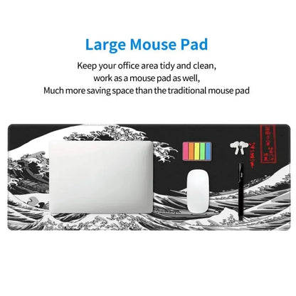 Large black and white desk mat featuring a stylized ocean wave design, holding a laptop, mouse, pen, and notes.
