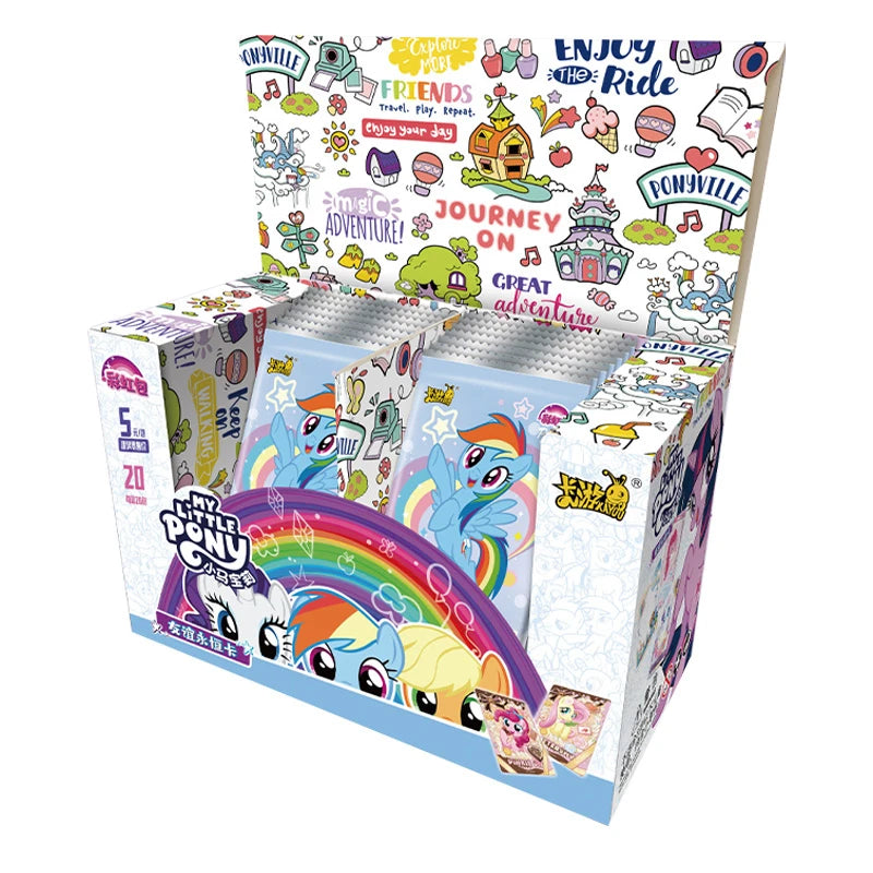 An open My Little Pony trading card box filled with foil packs featuring Rainbow Dash, with colorful Ponyville graphics.