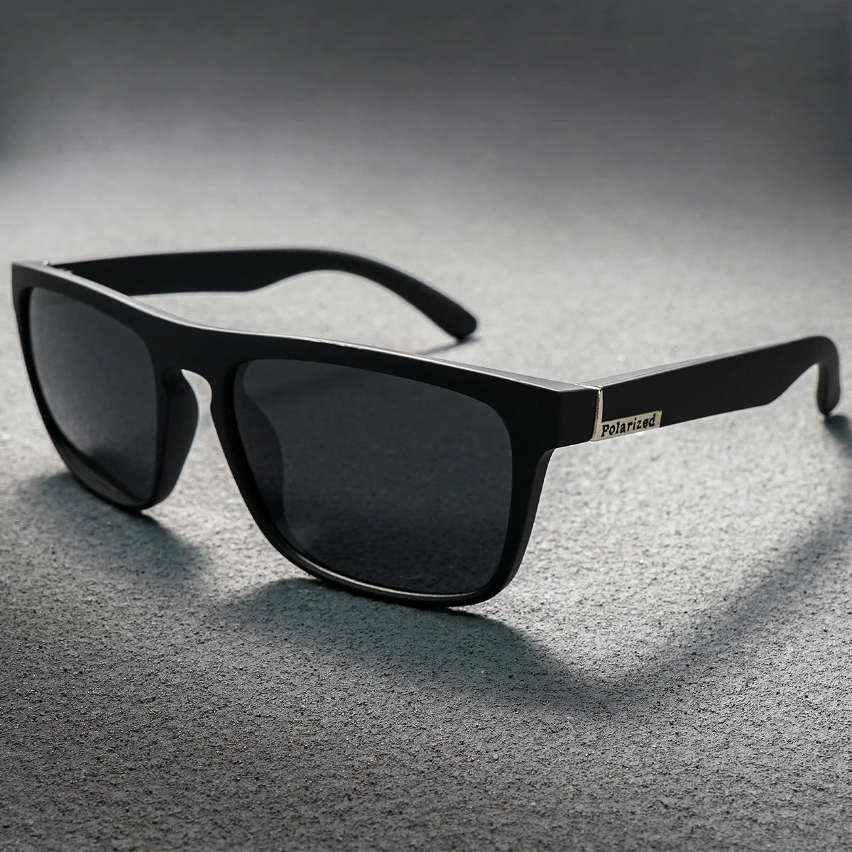 Matte black square sunglasses with dark lenses and a silver "Polarized" emblem on the temple.