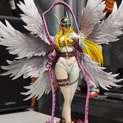 Angewomon PVC statue with large white feathered wings, blonde hair, silver helmet, and a pink rune ribbon.