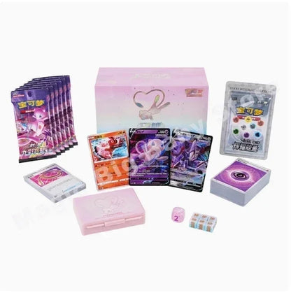 Pokemon Mew-themed gift box set with purple booster packs, cards, pink deck box, dice, and energy tokens.