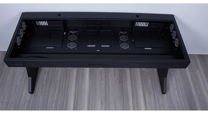 Overhead view of a large black computer desk with a hollow, partitioned chassis integrated into the top.