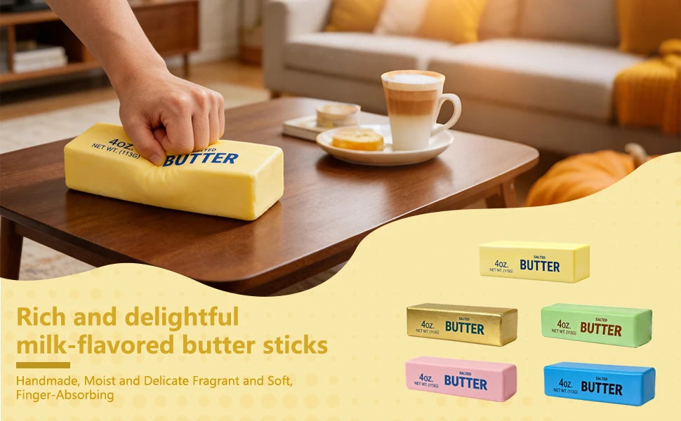 A hand squeezes a yellow stick of butter labeled "4oz. BUTTER" on a wooden coffee table, with four other colored butter sticks shown below.