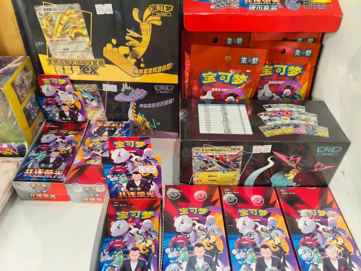 Assorted Simplified Chinese Pokémon TCG booster boxes and packs featuring Gholdengo, Mewtwo, and Dragapult.