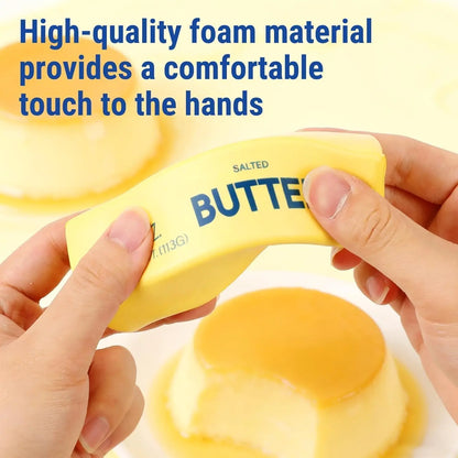 Hands squeeze a yellow butter-shaped stress toy labeled "BUTTER" and "SALTED".
