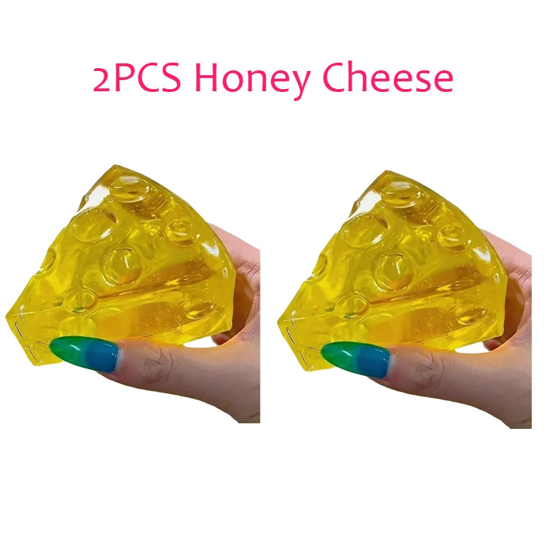 Two hands hold two identical, translucent yellow cheese wedge fidget toys with holes, captioned "2PCS Honey Cheese".