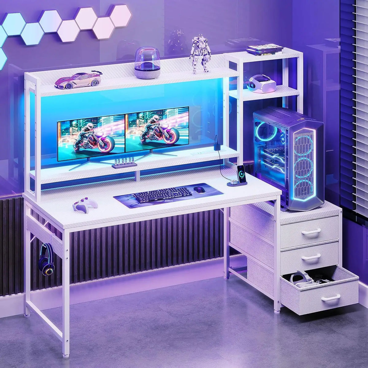 White gaming desk with hutch, shelves, dual monitors, PC tower, LED lighting, and three fabric drawers.