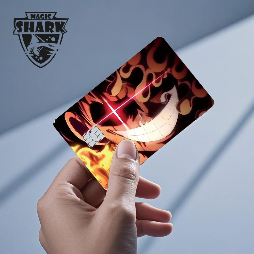 A hand holds a credit card skin featuring a dark anime character with glowing red eyes and a wide white grin amid flames.