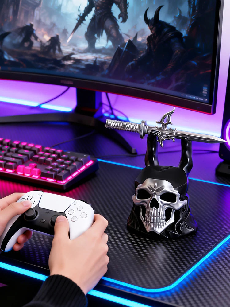Black and silver skull controller bracket holding a sword on a desk with a keyboard and glowing monitor.