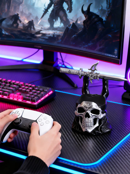 Black and silver skull controller bracket holding a sword on a desk with a keyboard and glowing monitor.