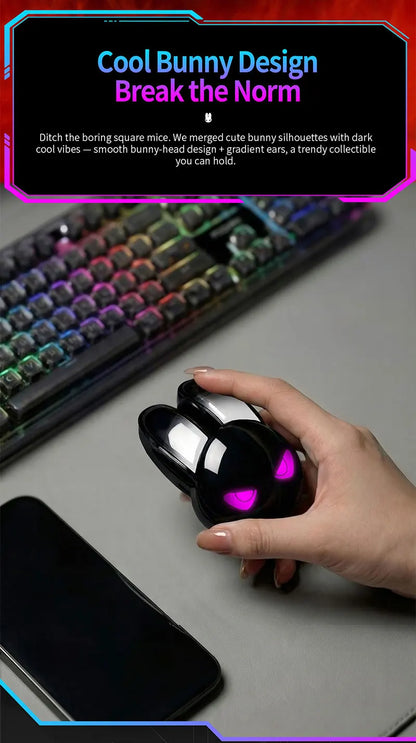 Black rabbit-shaped wireless mouse held in a hand, featuring glowing pink eyes and white-tipped ears.