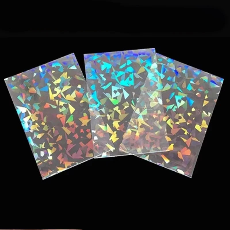 Three translucent card sleeves with a holographic shattered glass pattern reflecting multi-colored light.