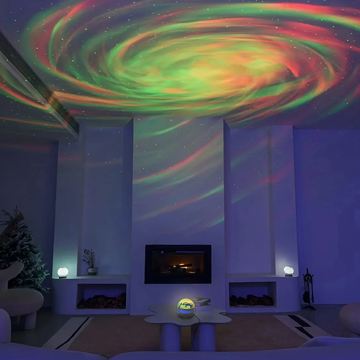 A small round galaxy lamp on a table projects red and green swirling northern lights and stars onto the ceiling and walls.
