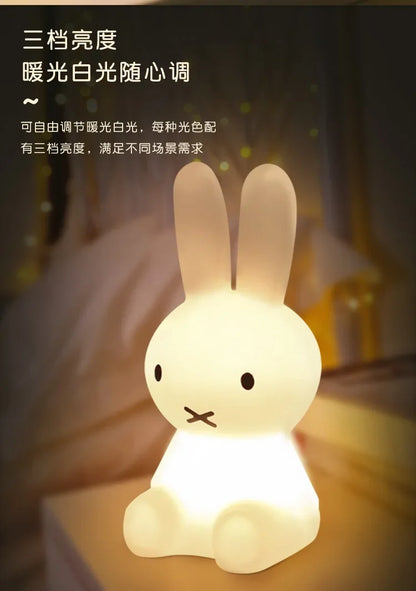 A glowing white Miffy night light shaped like a sitting rabbit with black dot eyes and an X-shaped mouth.