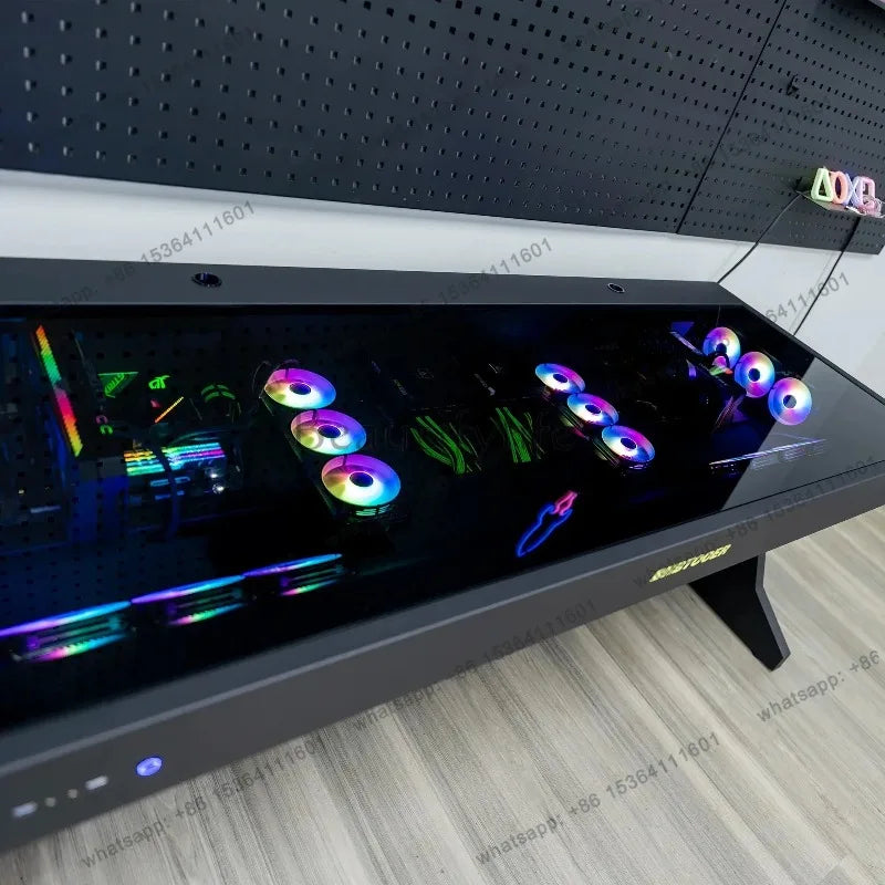 Black computer desk with an integrated glass-top chassis housing two glowing RGB PC builds.