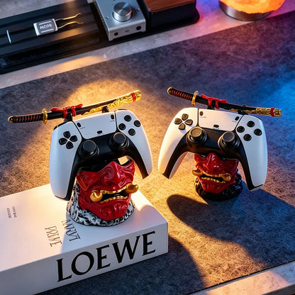 Two red samurai oni mask stands hold white game controllers and miniature swords.