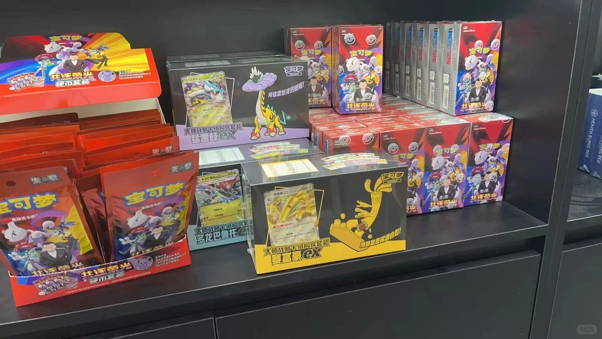 Simplified Chinese Pokémon TCG booster boxes and packs in red, black, and multicolored packaging on a shelf.