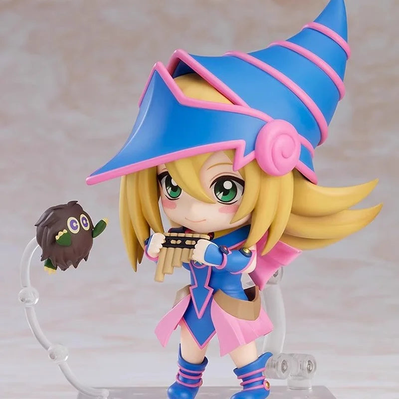 Chibi Dark Magician Girl figure in blue and pink, playing a flute with a small Kuriboh floating nearby.