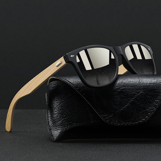 Black square sunglasses with light wood temples rest on a black textured case.