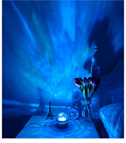 A blue starry lamp projector on a nightstand, casting a blue nebula light across the wall.