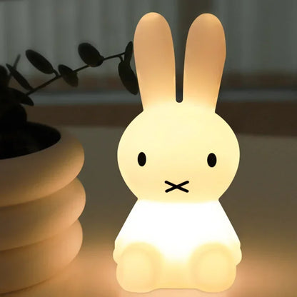 A glowing white Miffy night light shaped like a sitting rabbit with long ears, black eyes, and an 'X' mouth.