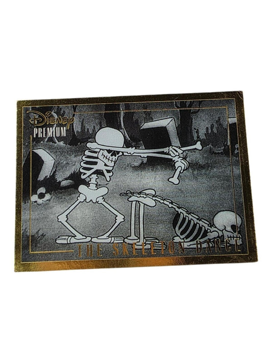 Black and white Disney Skeleton Dance trading card featuring two skeletons in a graveyard, with gold foil border and text.