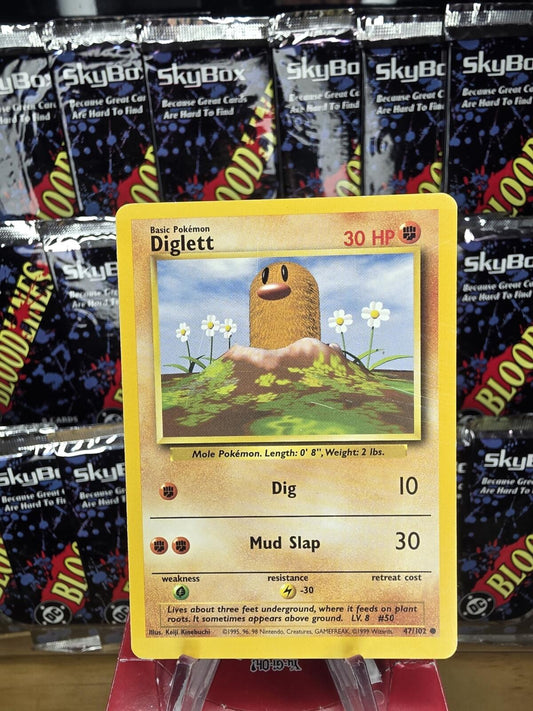 A yellow Diglett 30 HP Pokémon card, with white flowers and a brown mole against a blue sky.