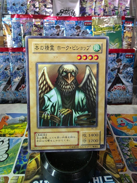 Japanese Spirit of the Books trading card featuring a winged creature in a robe, with booster packs in the background.