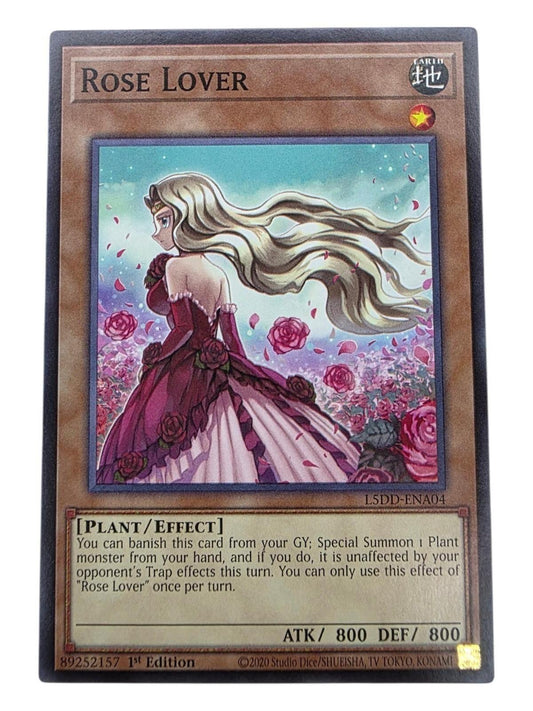 Rose Lover 1st Edition Yu-Gi-Oh! card featuring a blonde woman in a pink dress among roses.