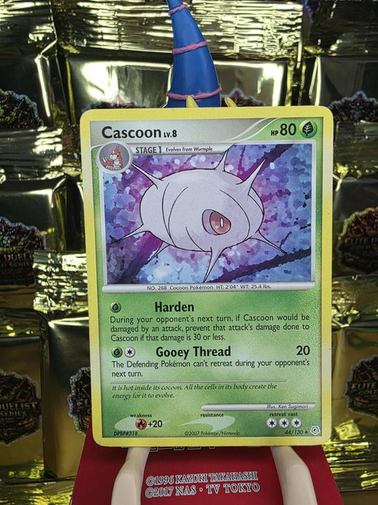 Green Pokemon Cascoon trading card with a white, spiky cocoon character against a purple background.