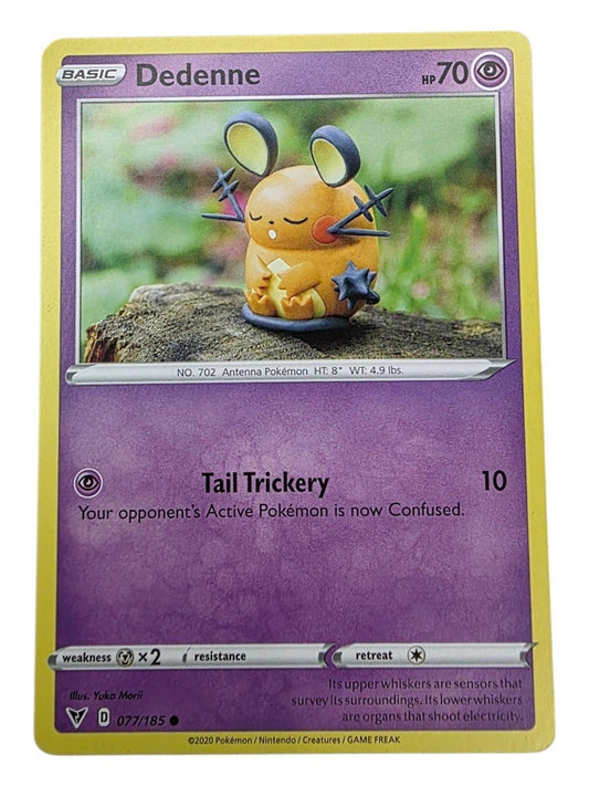 Dedenne 077/185 Vivid Voltage psychic Pokémon card featuring a clay figurine on a log.